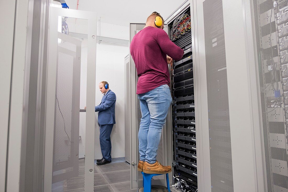 Technicians checking servers in data centre