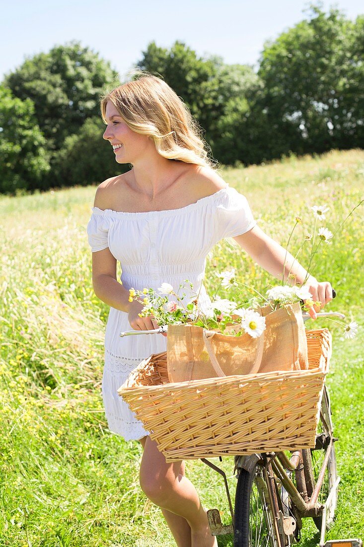 Woman in meadow with bicycle