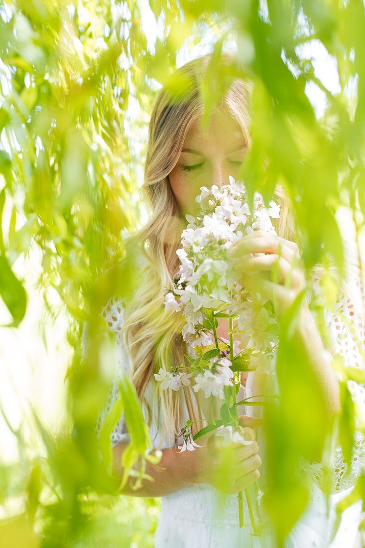 Woman smelling white flowers