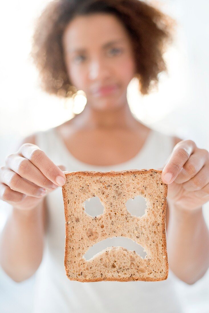 Woman holding bread with sad face