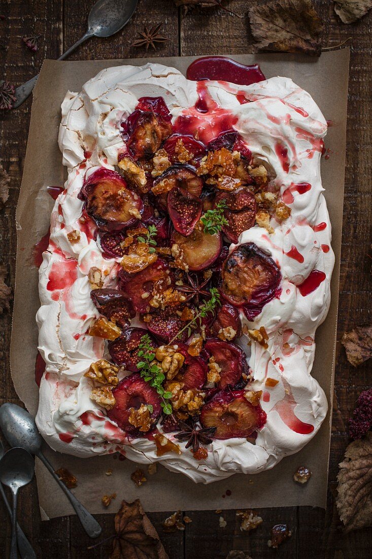 Pavlova with roasted figs, plums and walnut brittle