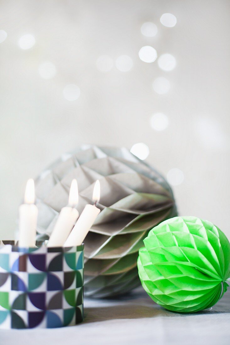 Honeycomb paper balls and candles in glass holder