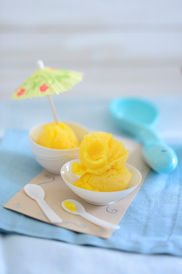 Mango ice cream with a cocktail umbrella