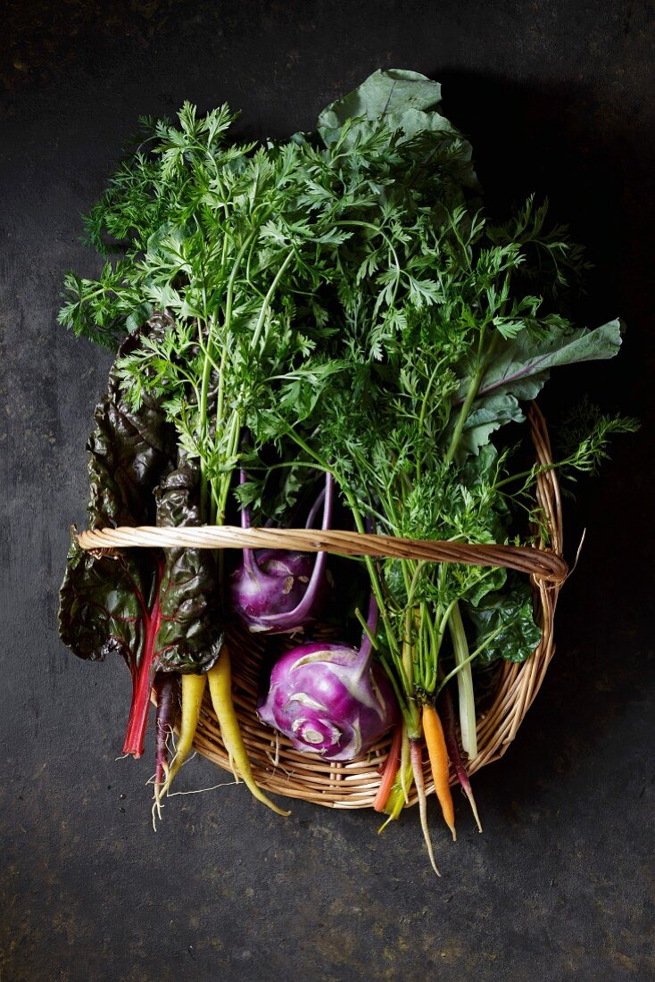 Mangold, bunte Karotten und Kohlrabi in Weidenkorb