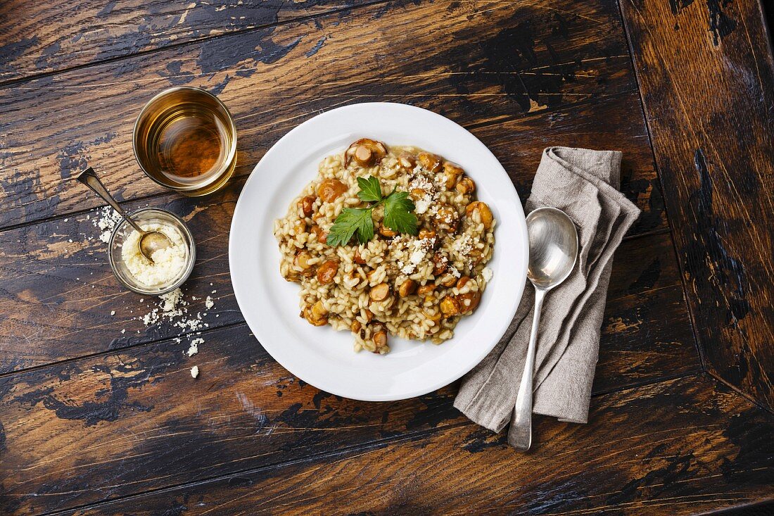 Risotto mit Pfifferlingen auf rustikalem Holztisch (Aufsicht)