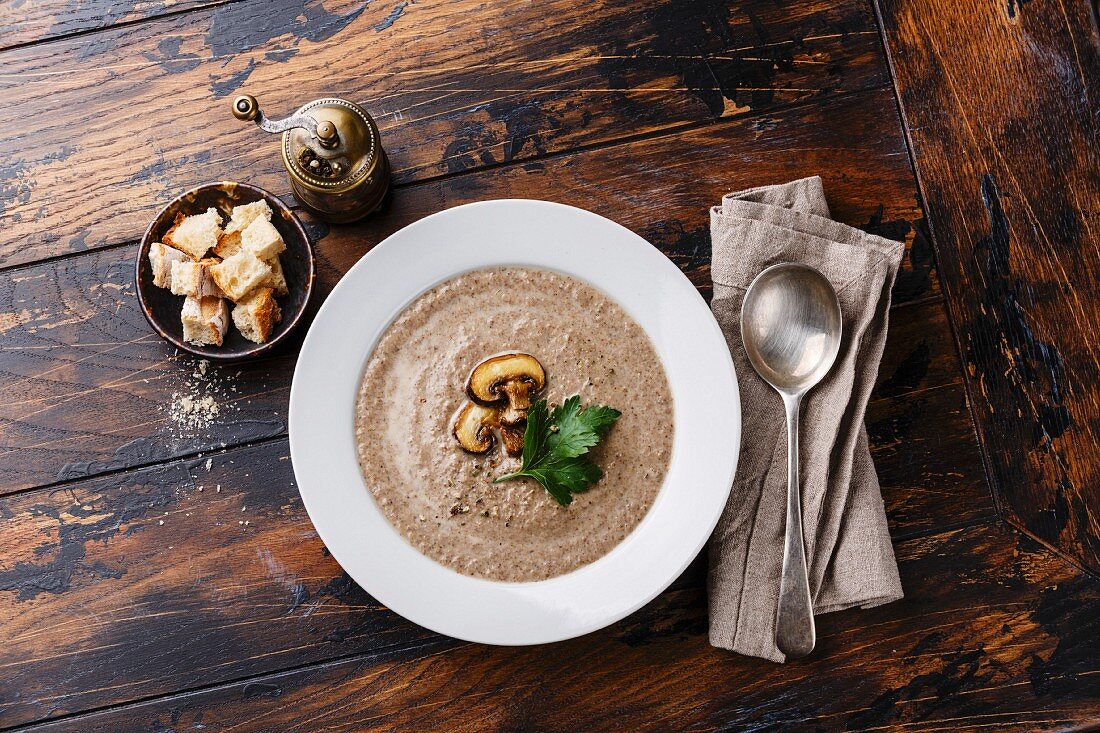 Mushroom soup with croutons on wooden table