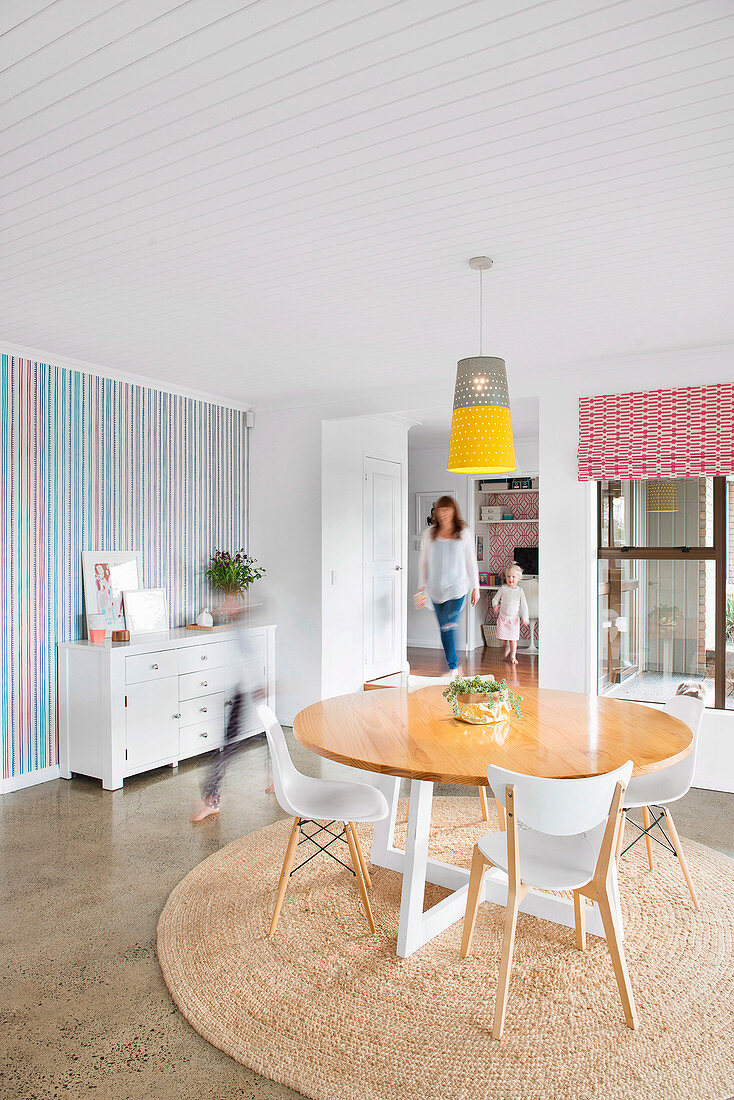 Family walks through modern dining room with round table