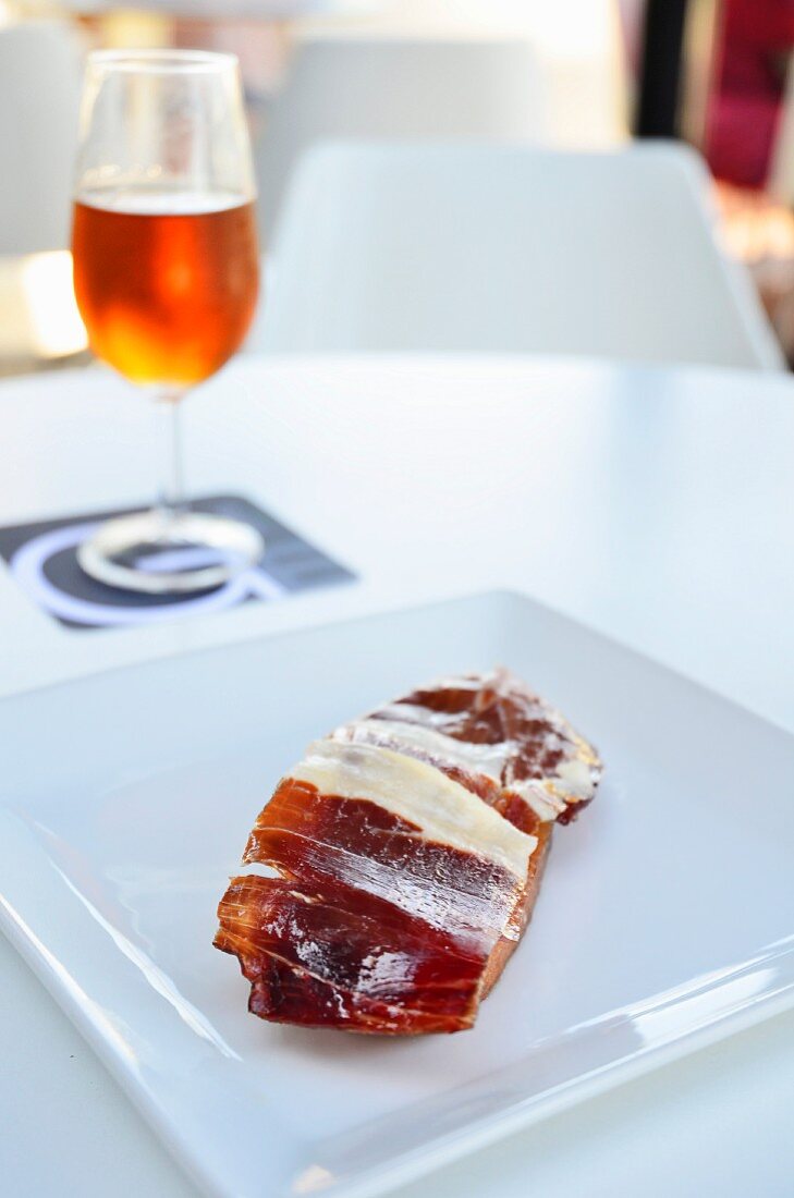 Iberian ham Pass on a white plate with a glass of Amontillado sherry