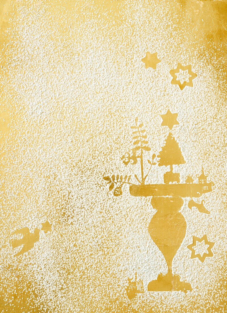 Christmas prints in icing sugar on a golden surface
