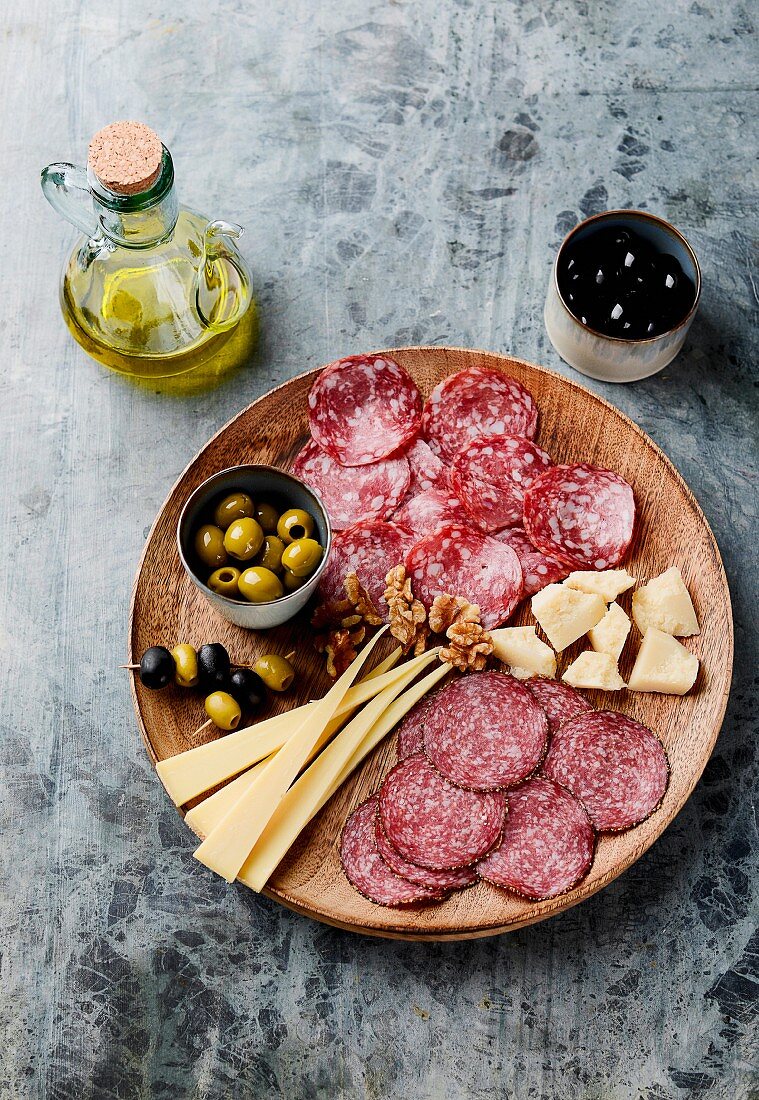 A cold cuts patter with salami, cheese and olives