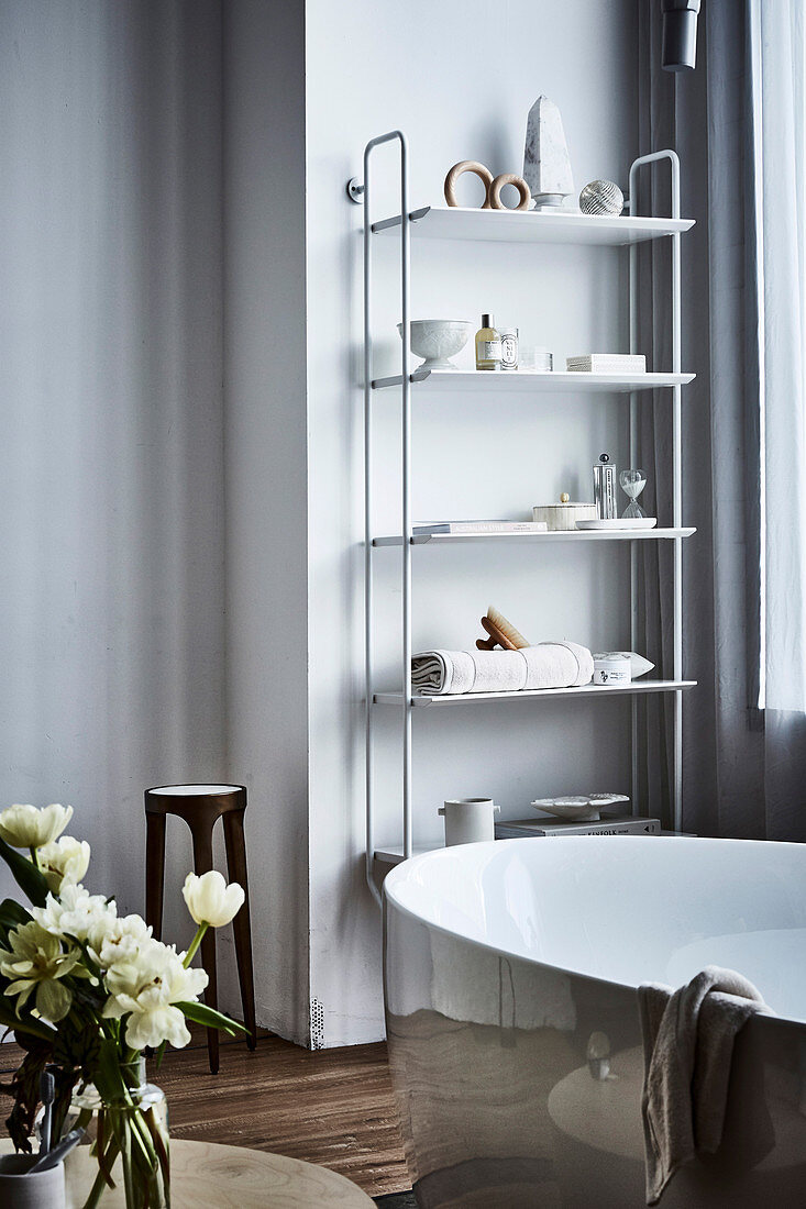 Shelf with bathing utensils, freestanding bathtub in front