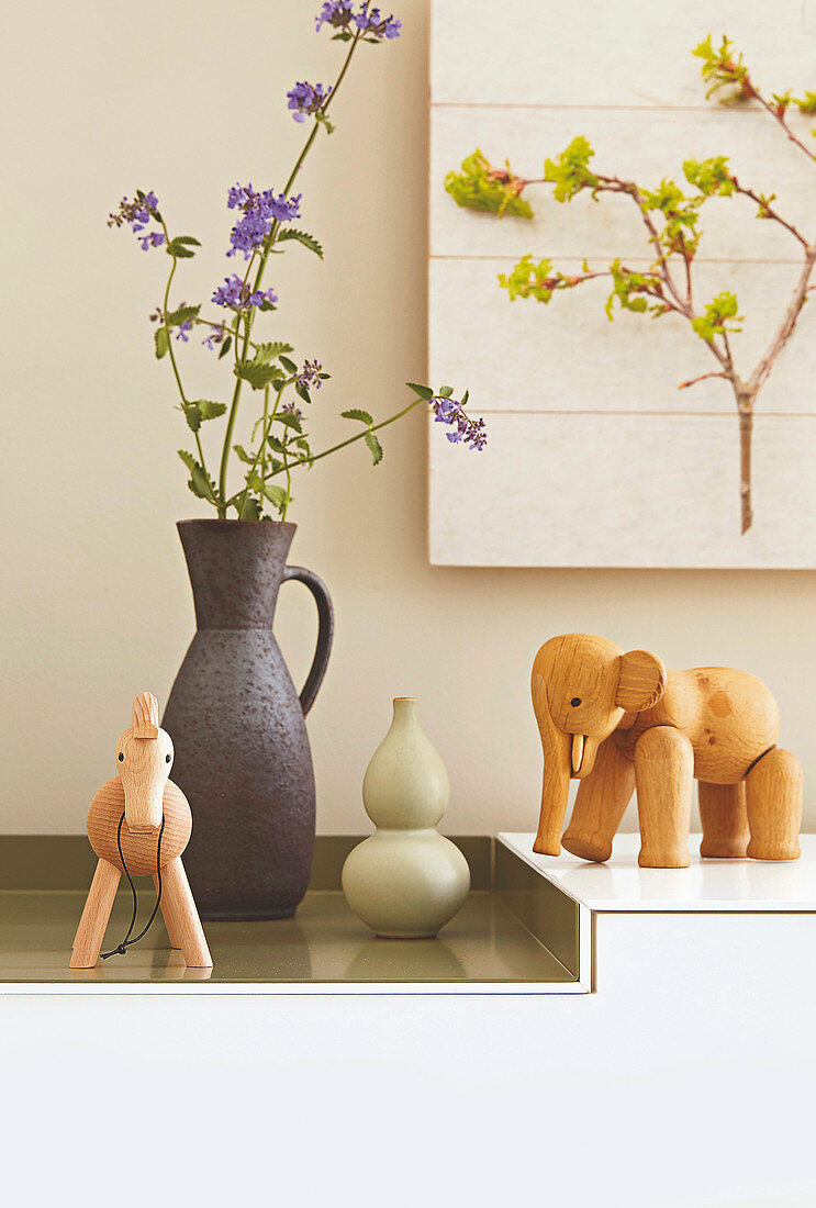 Wooden animal figures and ceramic vases on a sideboard