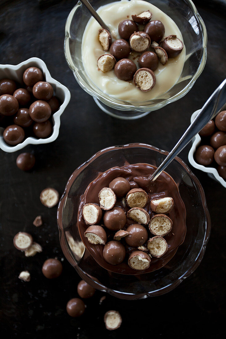 Schokoladen- und Vanillepudding mit Schokokugeln in Glasschalen