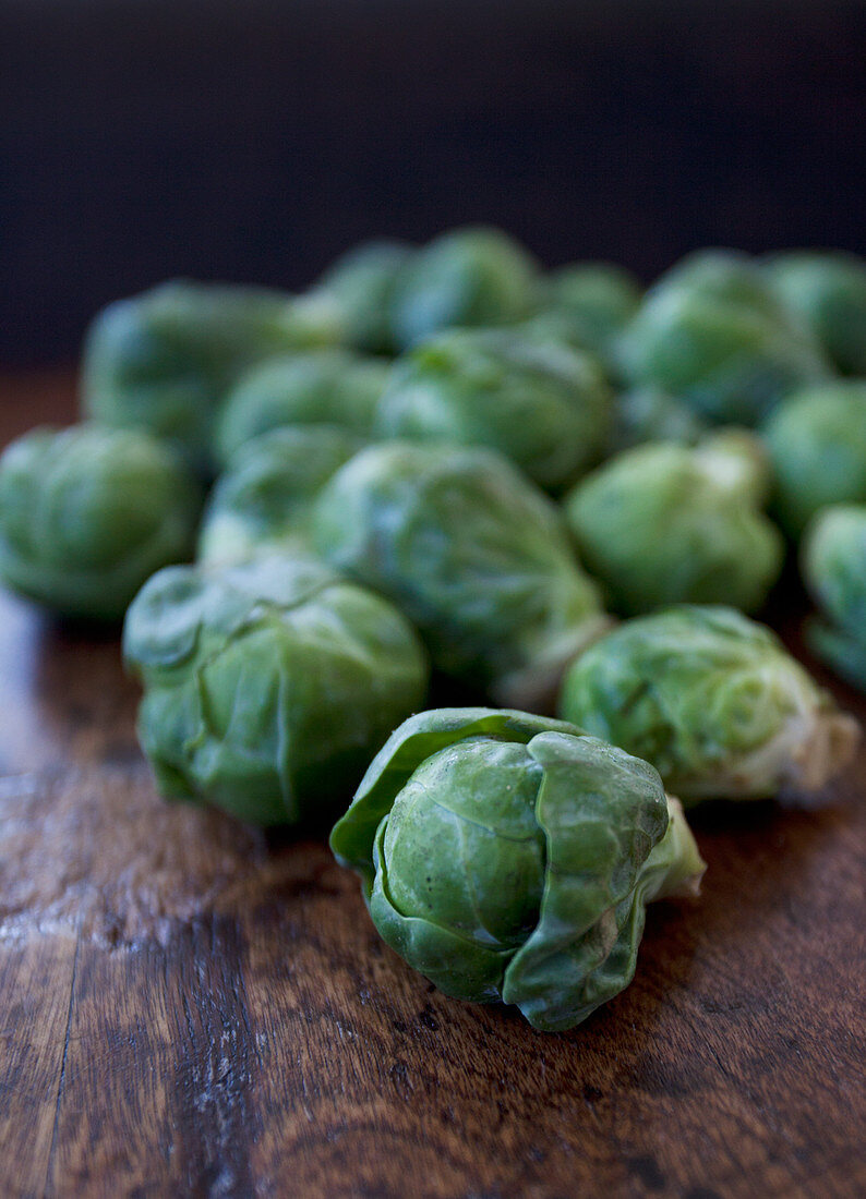 A pile of brussels sprouts on a wooden table