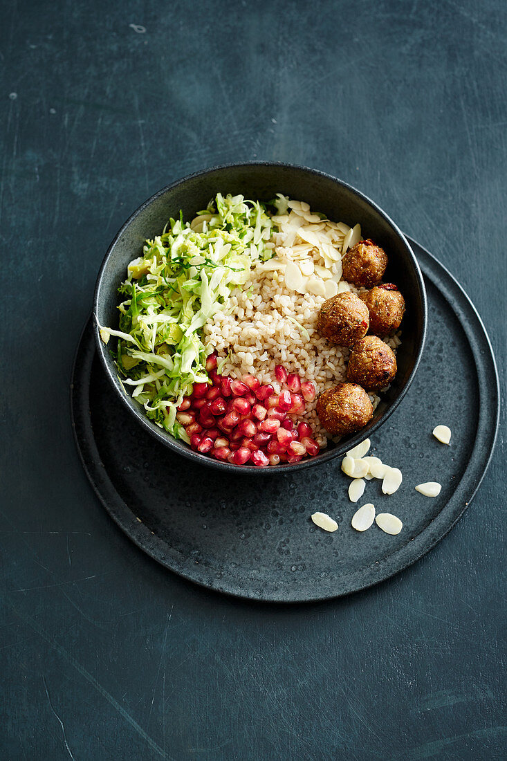 A healthy bowl with Brussels sprouts, freekeh balls and pomegranate seeds