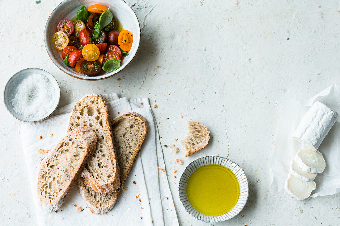 Helle Brotscheiben mit Olivenöl, Tomatensalat und Ziegenkäse