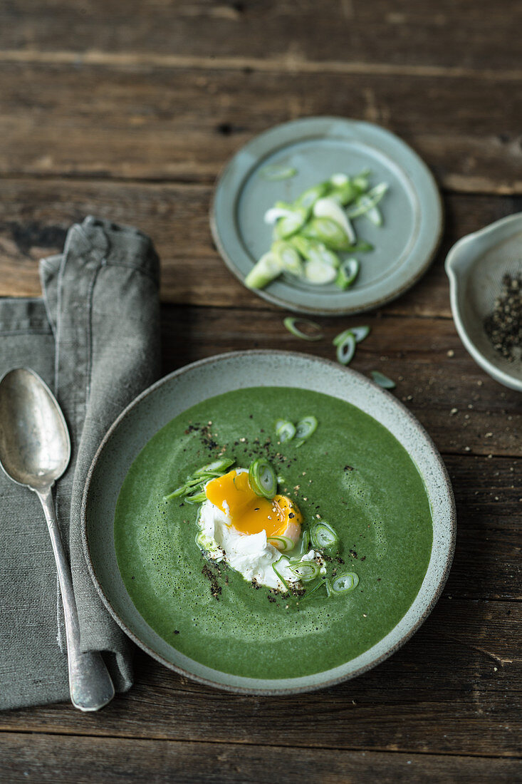 Green vegetable soup with poached eggs
