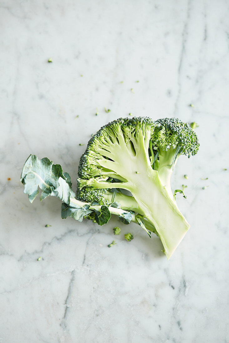 A broccoli floret on a marble surface