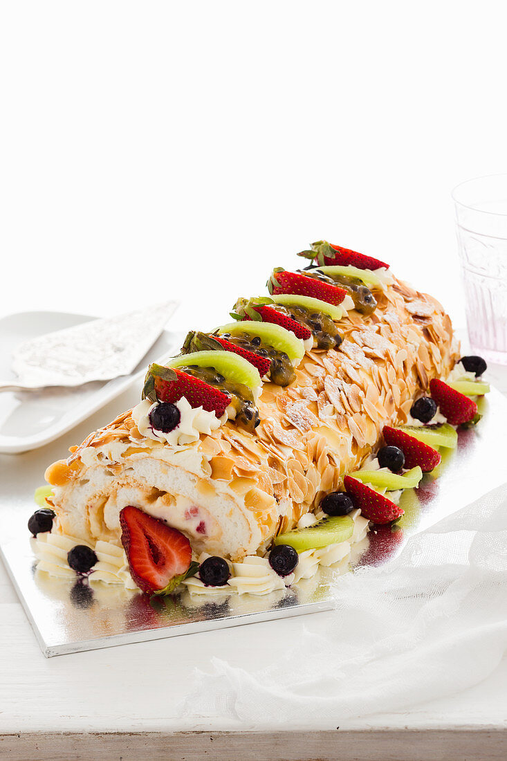 Rolled pavlova with fresh fruits and flaked almonds