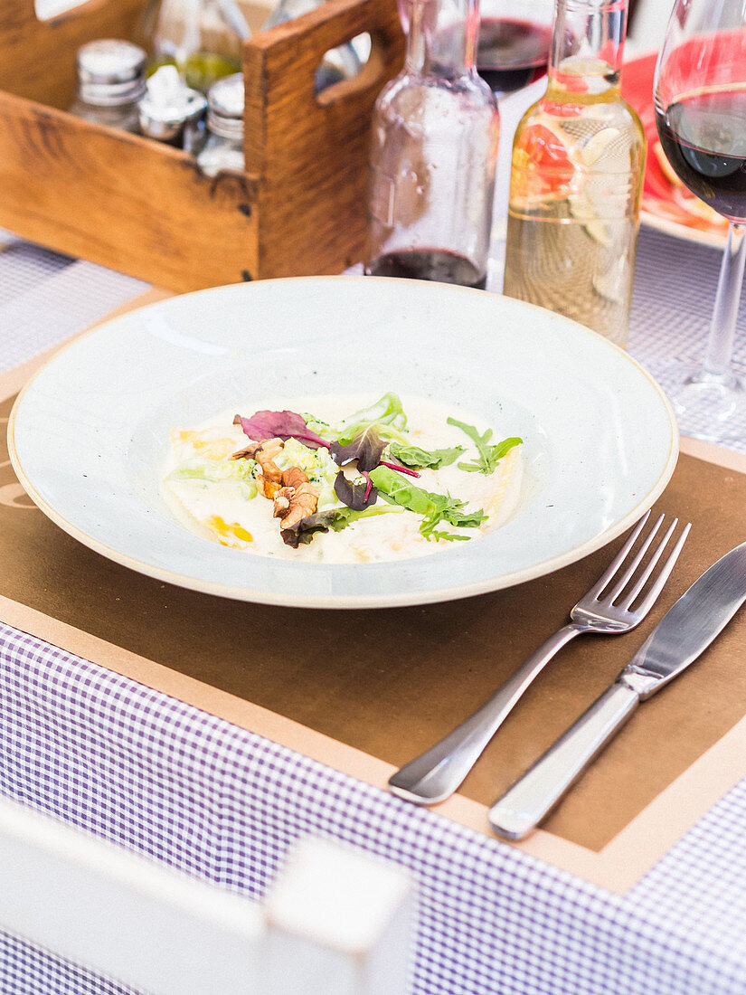 Ravioli mit Pistazien, Gorgonzola, Walnüssen und Brokkoli auf einem Gartentisch