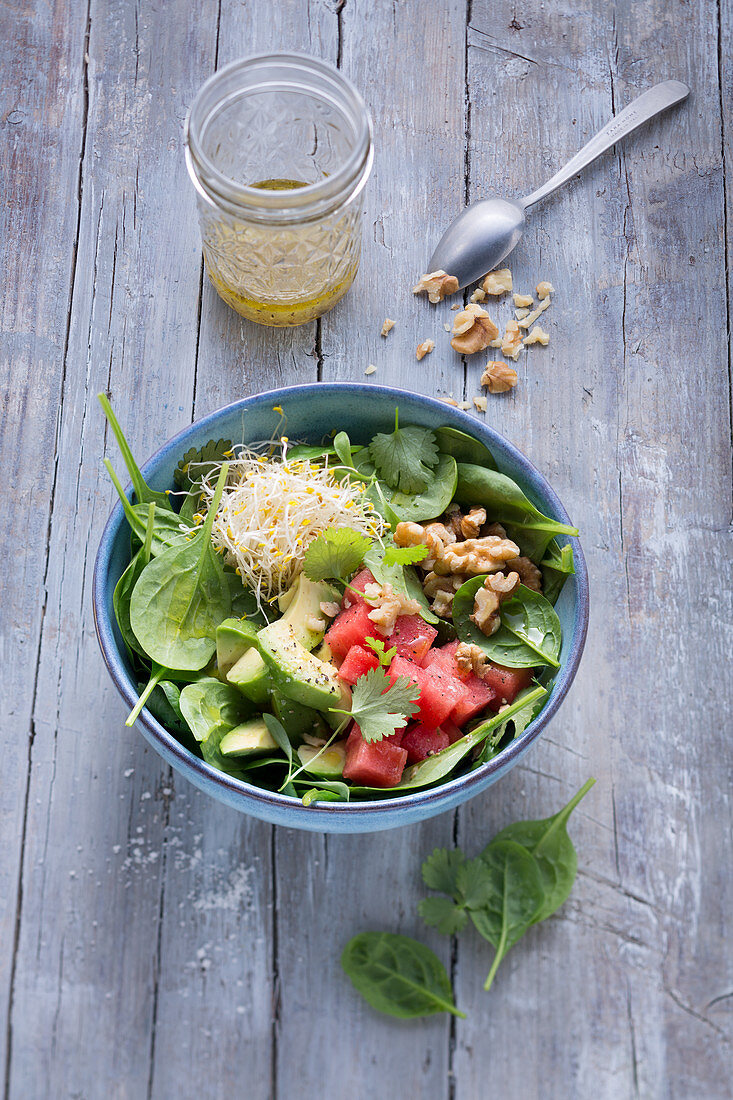 Spinach salad with avocado, watermelon and alfalfa shoots