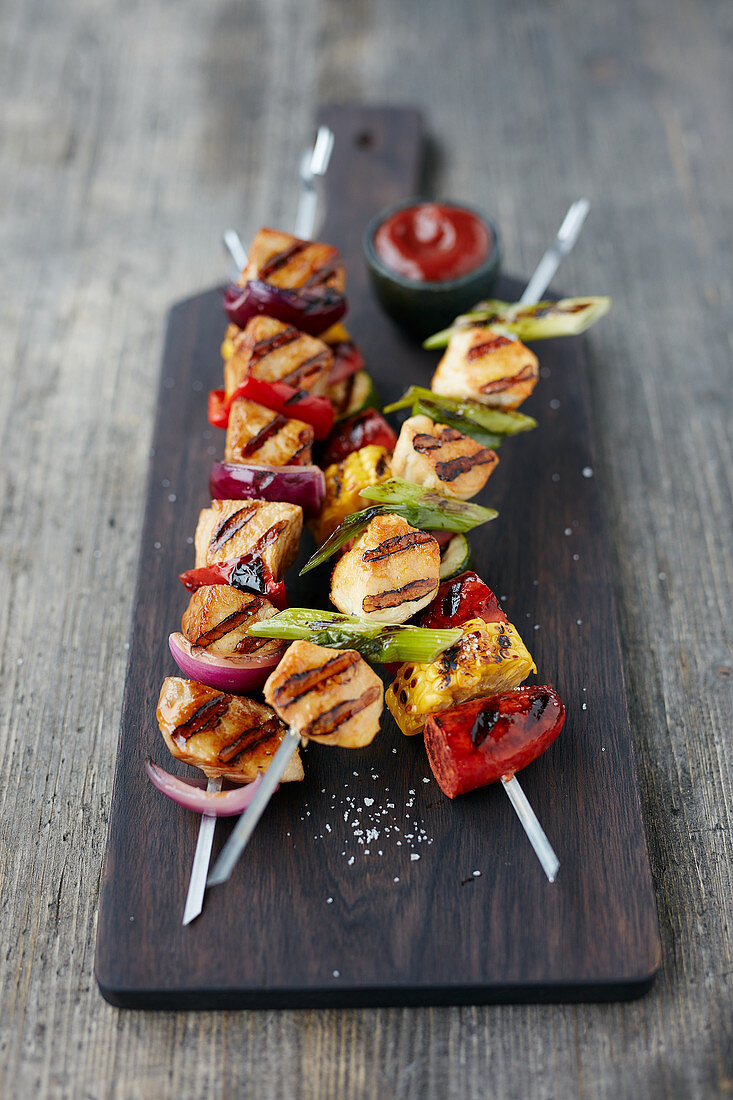 Barbecue skewers on a wooden chopping board