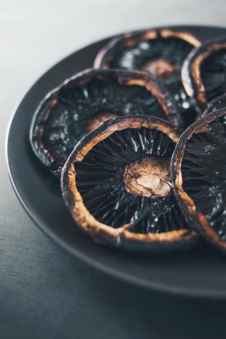 Fried portobello mushrooms on a black plate