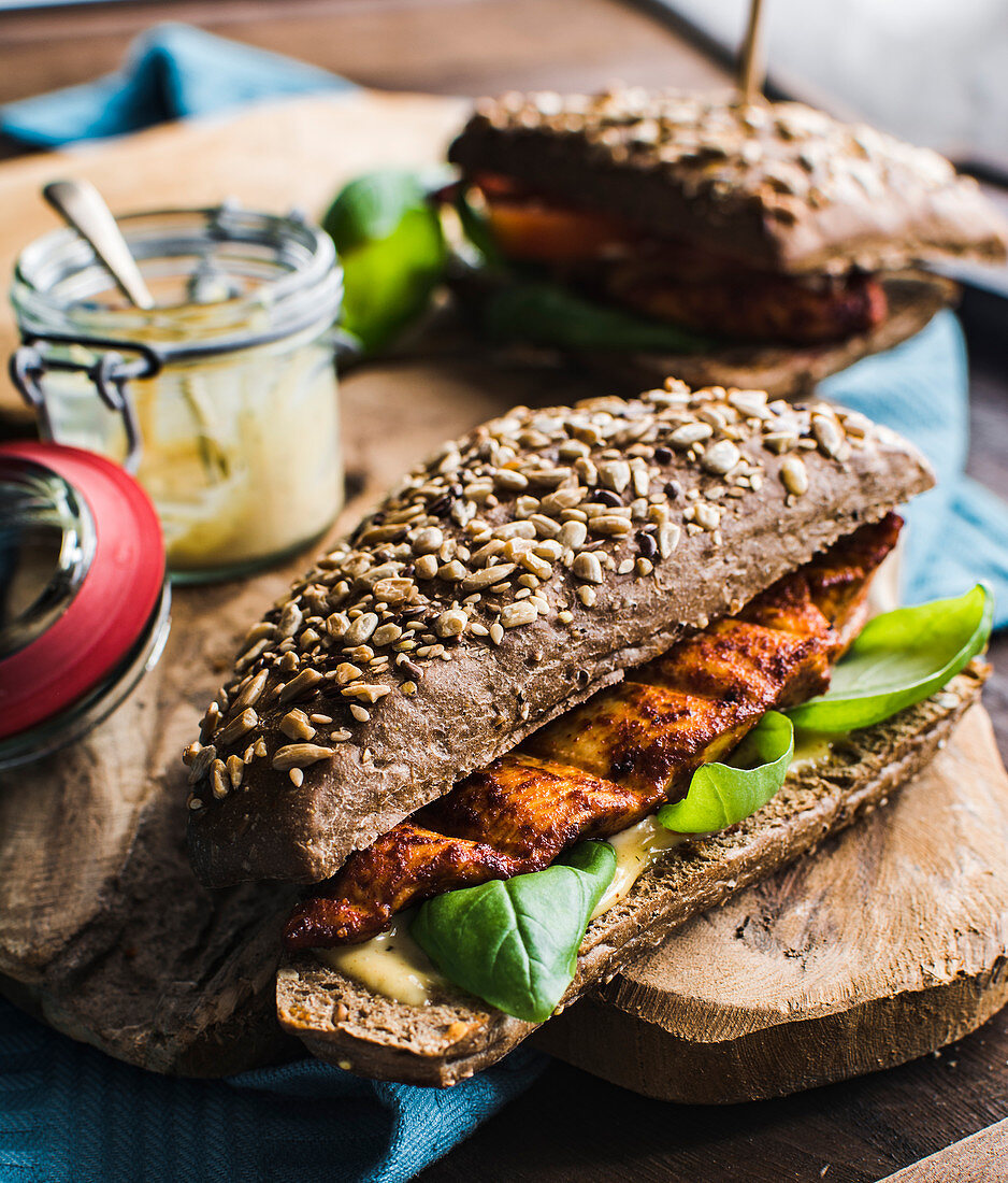 Marinated chicken breast in a wholegrain burger bun with mustard sauce and basil