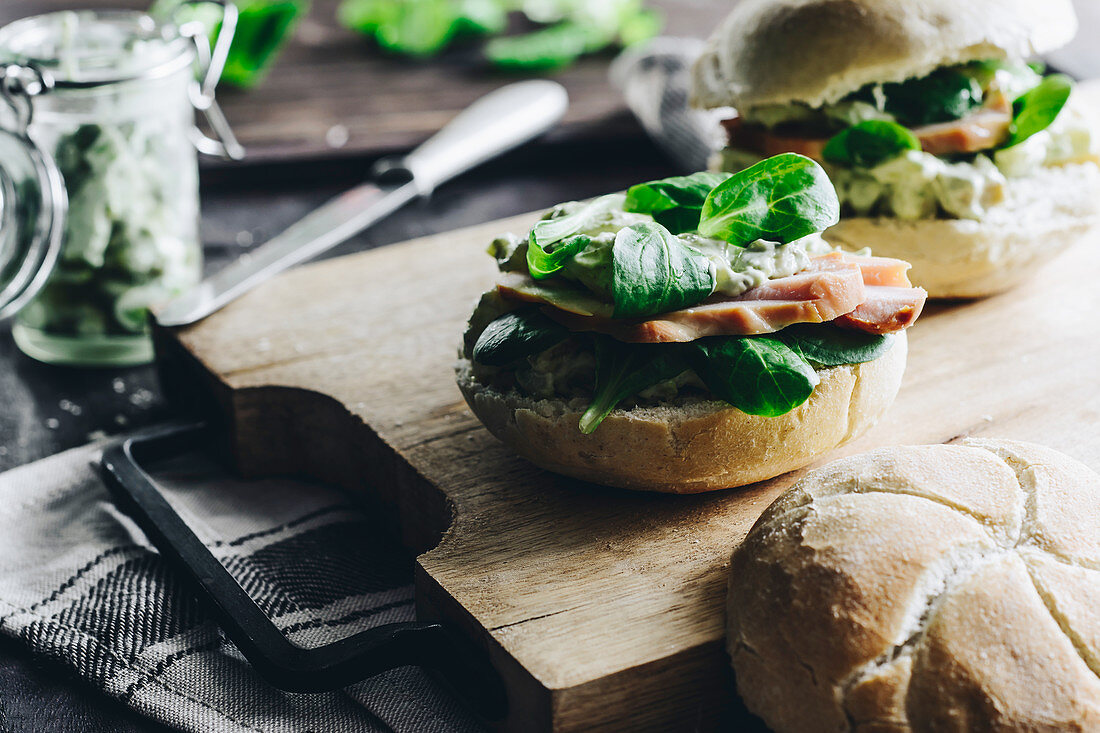 A crusty bread roll with lamb's lettuce, smoked chicken and avocado spread