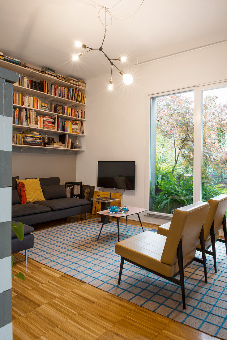 Bookcase above sofa in retro living room