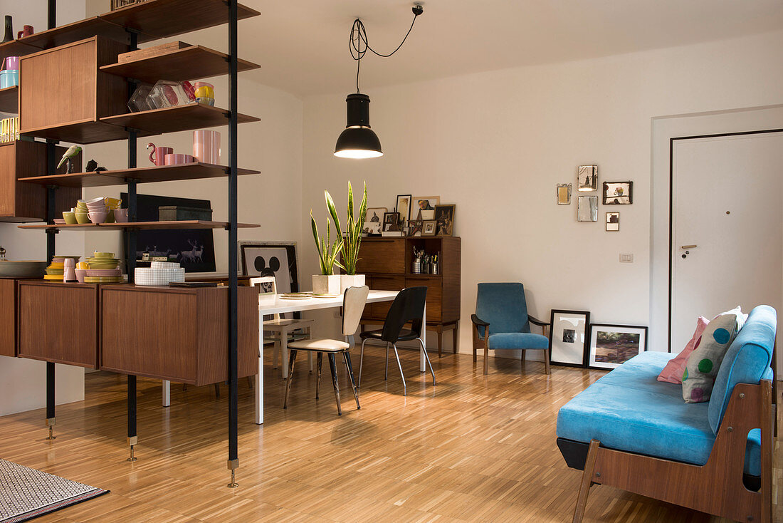 Blue sofa and dining area behind partition shelving