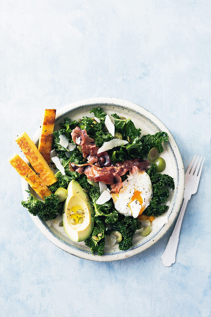 Grünkohlsalat mit Avocado, pochiertem Ei, Bacon und Polentaschnitten