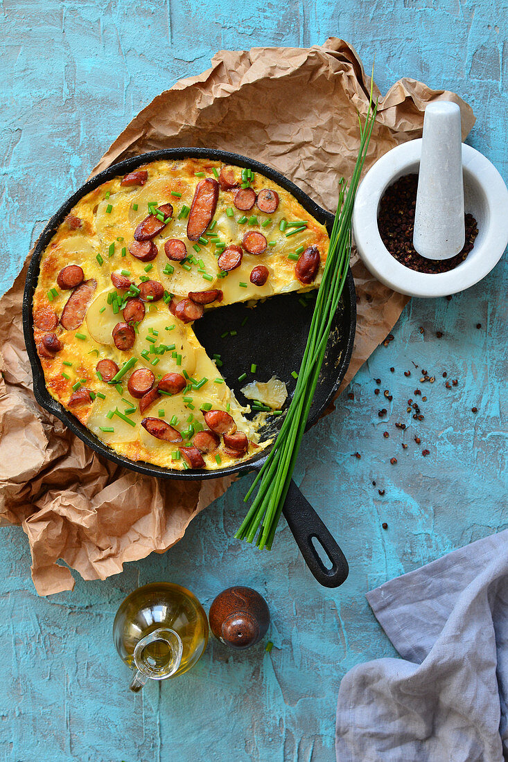 Paella in Pfanne mit Kartoffeln und Würstchen