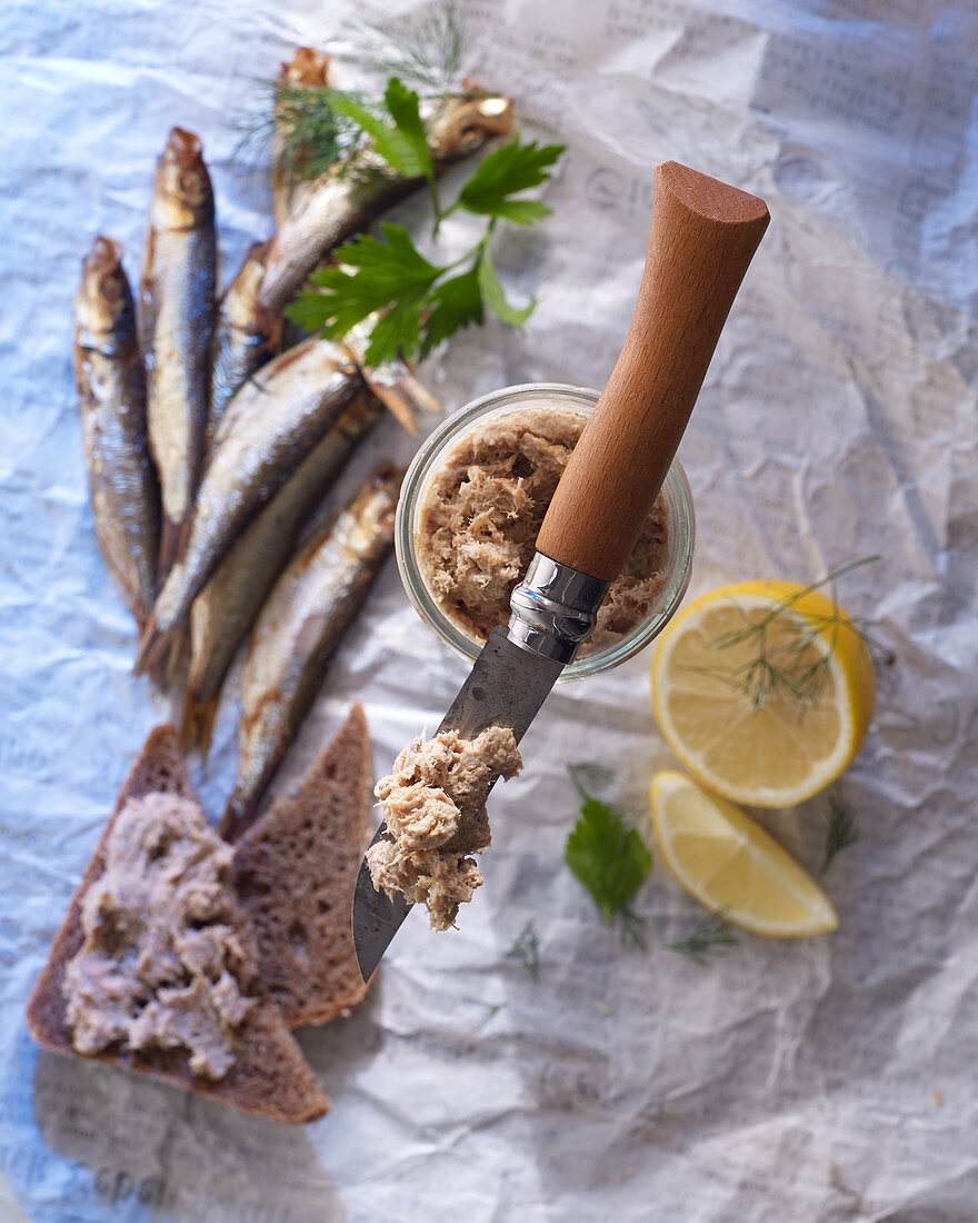 Mackerel rillette on an Opinel knife, with wholegrain bread, fresh mackerel, and lemon wedges