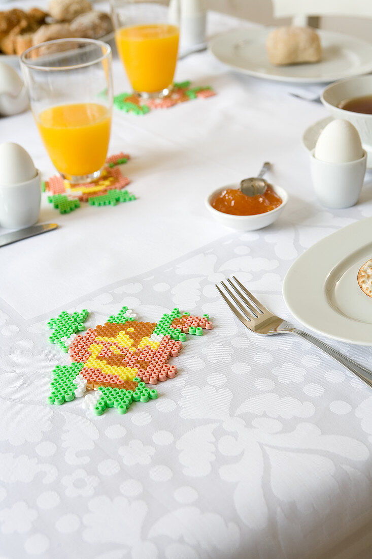 Hand-made fusion-bead coasters on table set for spring breakfast