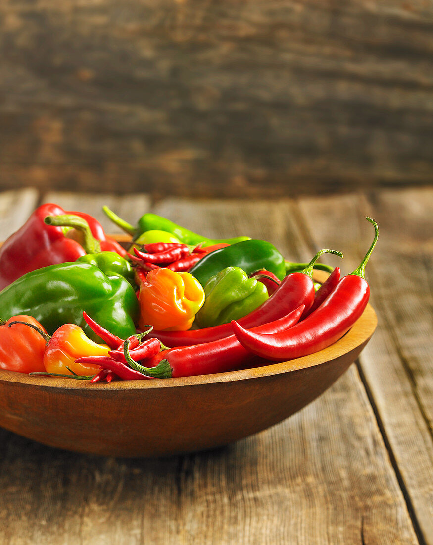 Paprika- und Chilischoten in einer Holzschale