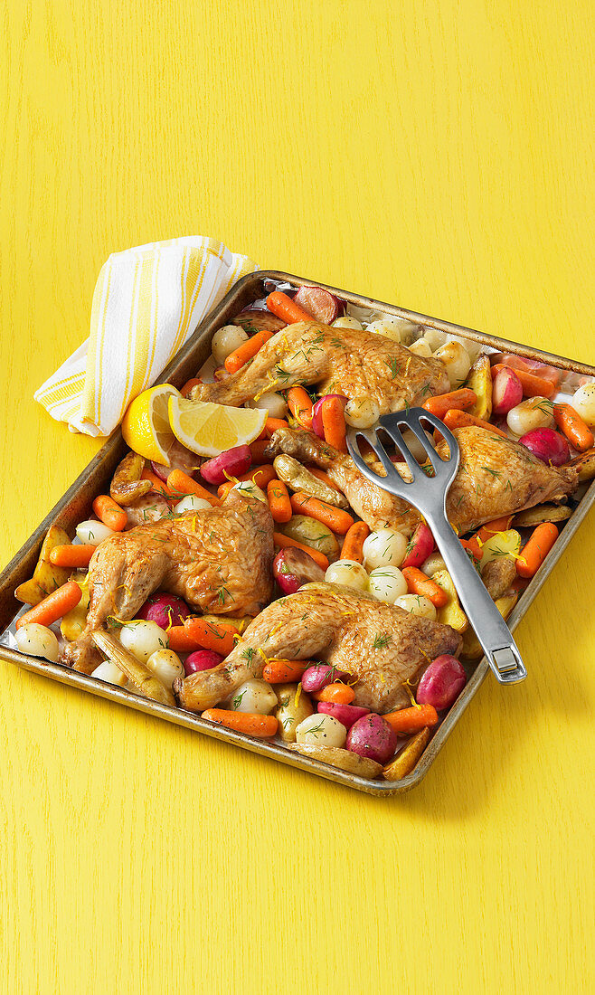 Chicken legs with vegetables on a baking sheet