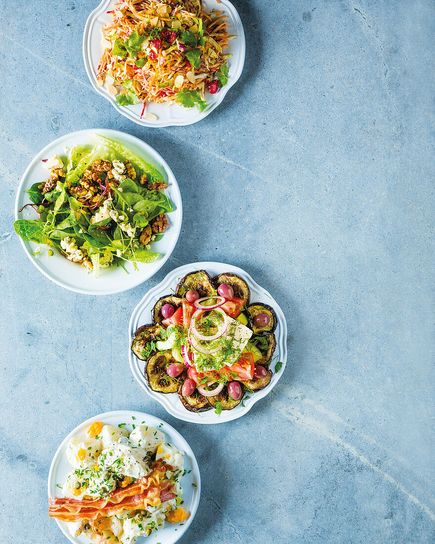 Various salads: raw salad, lettuce salad with walnuts and blue cheese, aubergine salad and potato salad