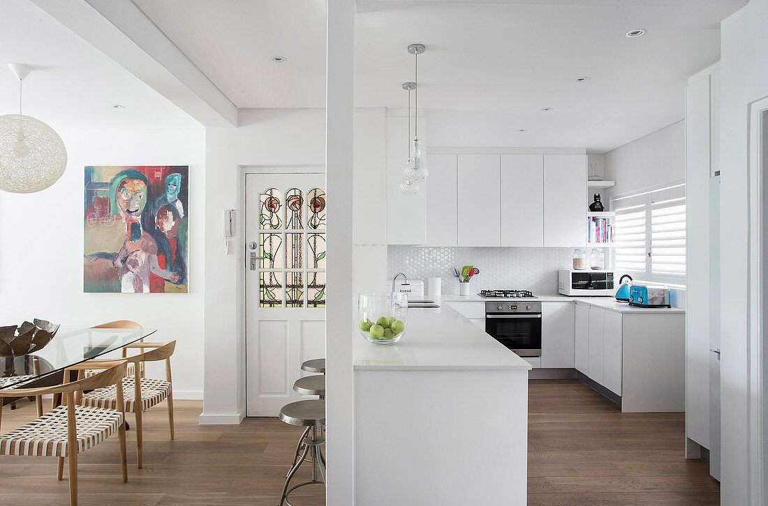 Counter used as partition in white fitted kitchen