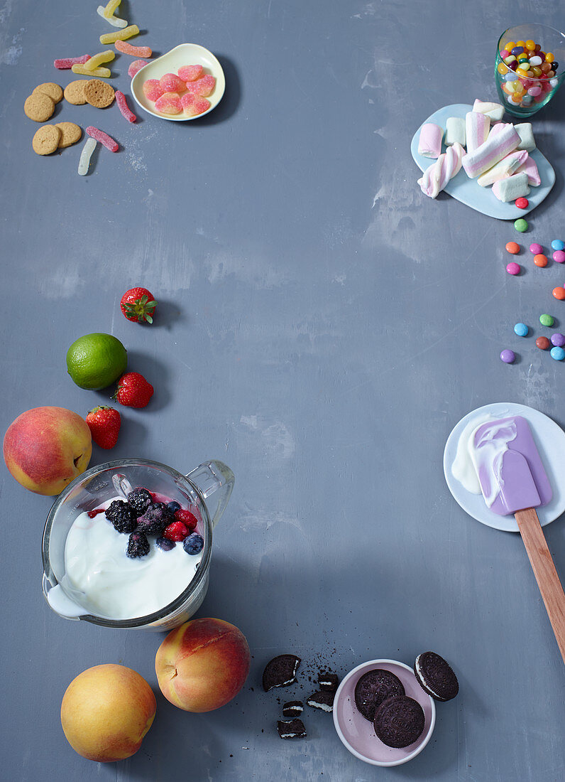 Ingredients for frozen yoghurt desserts (yoghurt, fruit, biscuits, sweets)