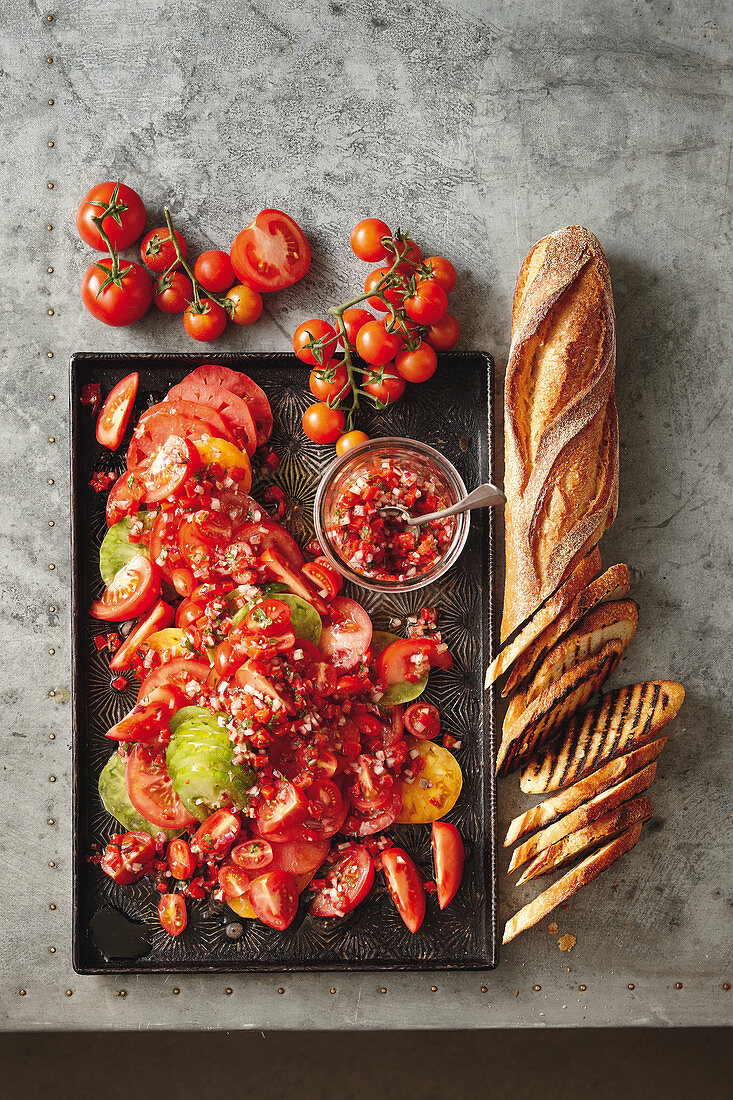 Tomatensalat mit Paprika und Chilis, dazu Baguette
