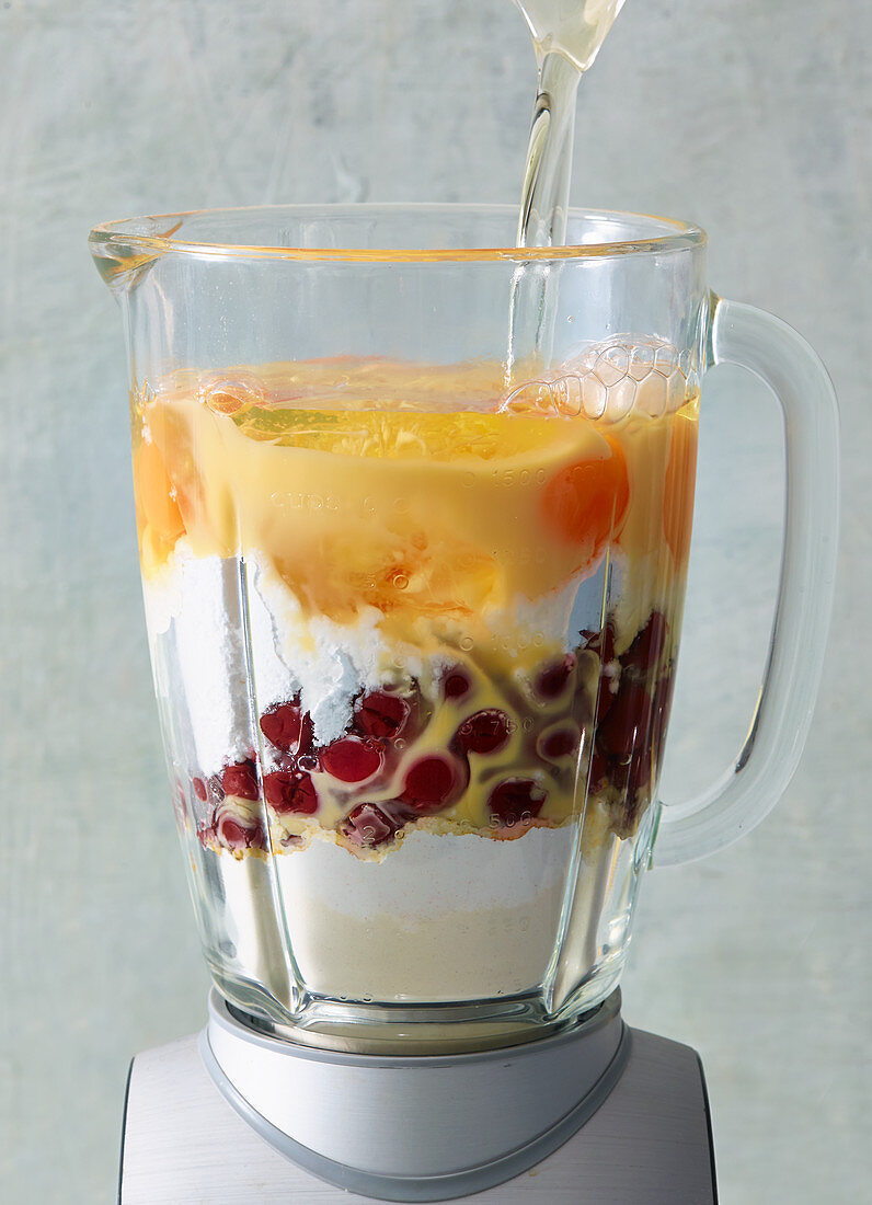 Ingredients for a cherry and egg liqueur cake in a blender