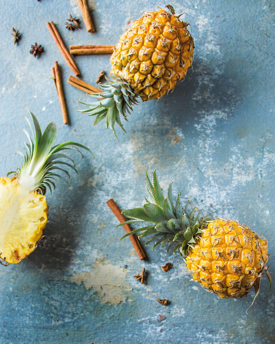 An arrangement of pineapples with cinnamon and star anise