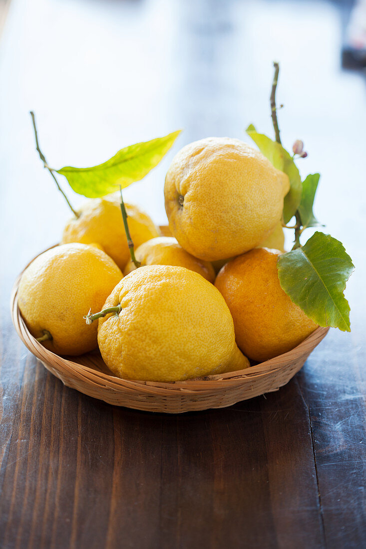 Frische Zitronen mit Blättern im Korb