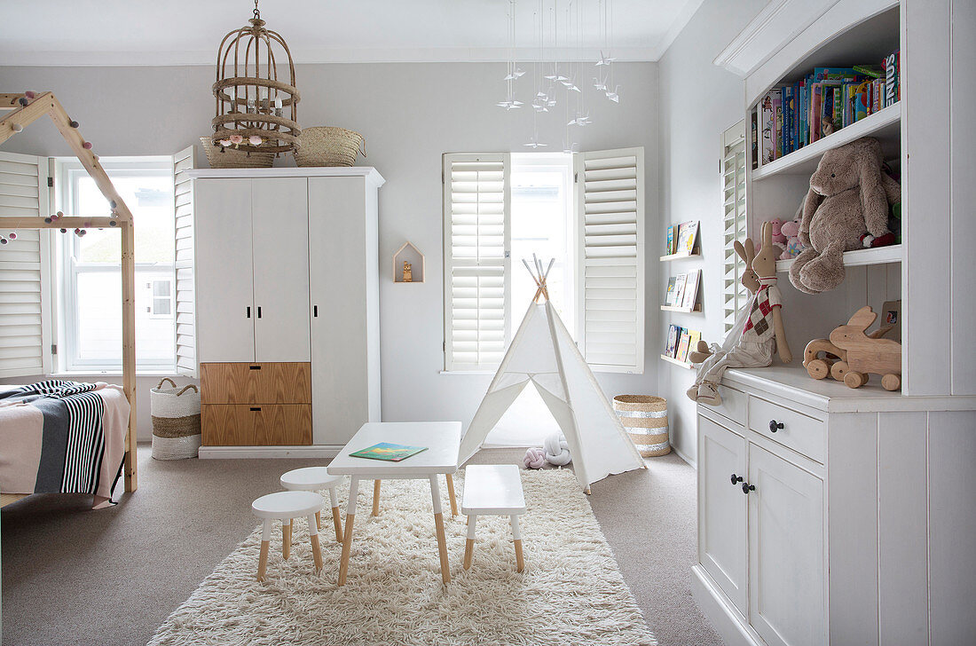 White furniture and teepee in bright child's bedroom