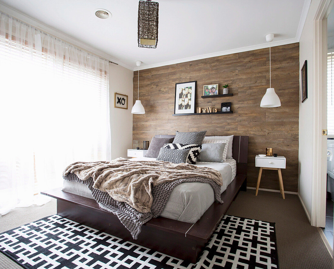 Earth-colored bedroom with wood-clad wall