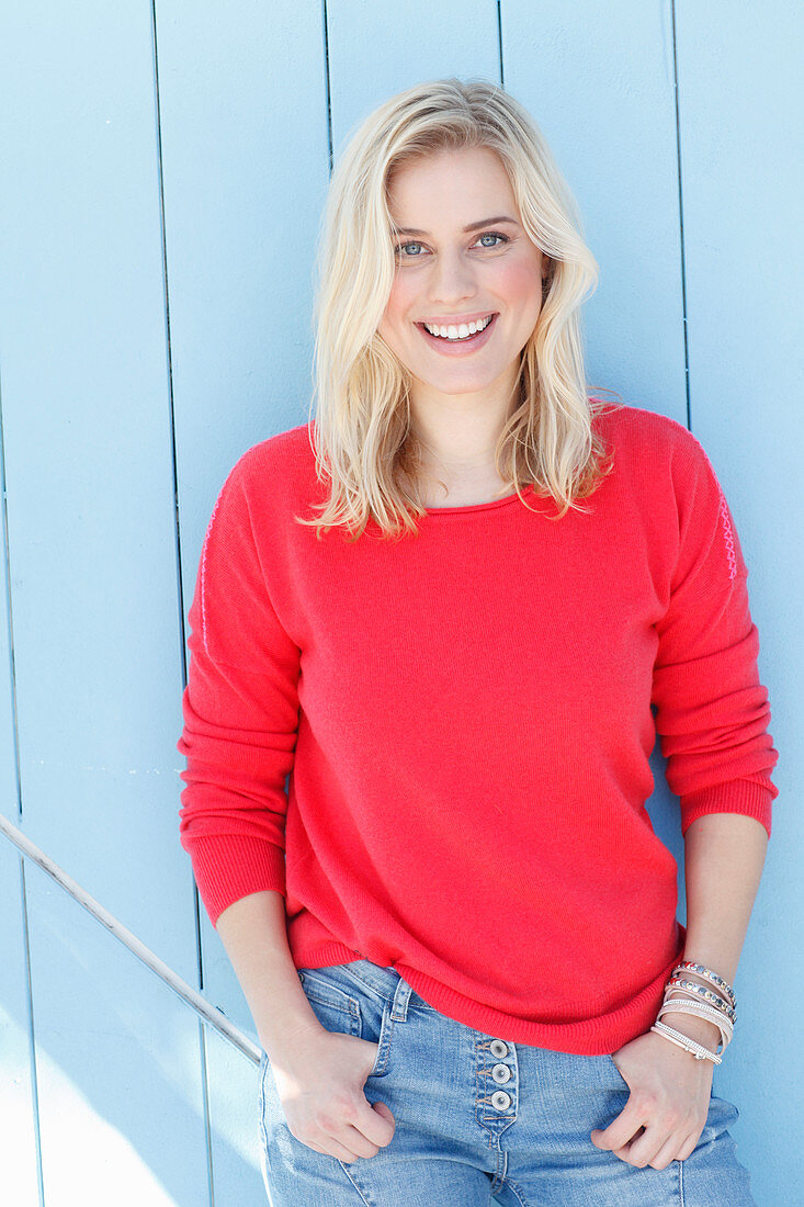 A young blonde woman wearing a red jumper