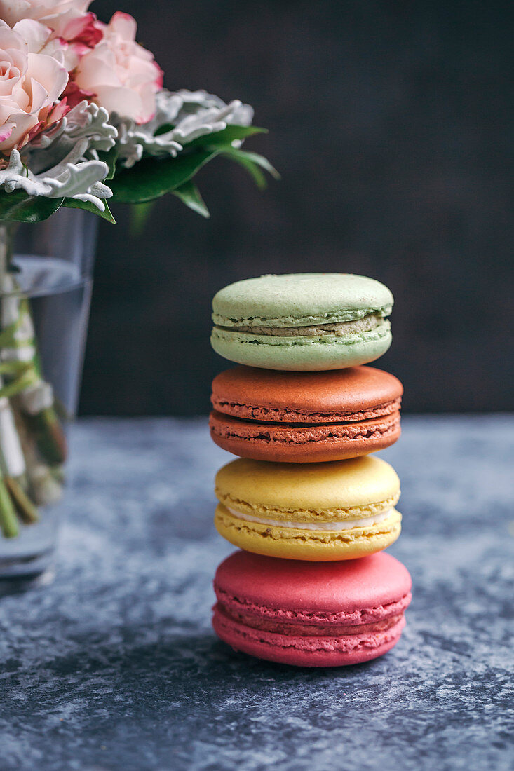 Ein Stapel bunter Macarons auf grauem Untergrund