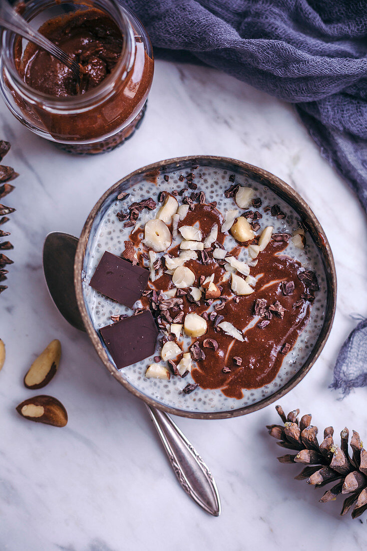 Chia pudding with homemade chocolate hazelnut spread topped with nuts and cacao nibs