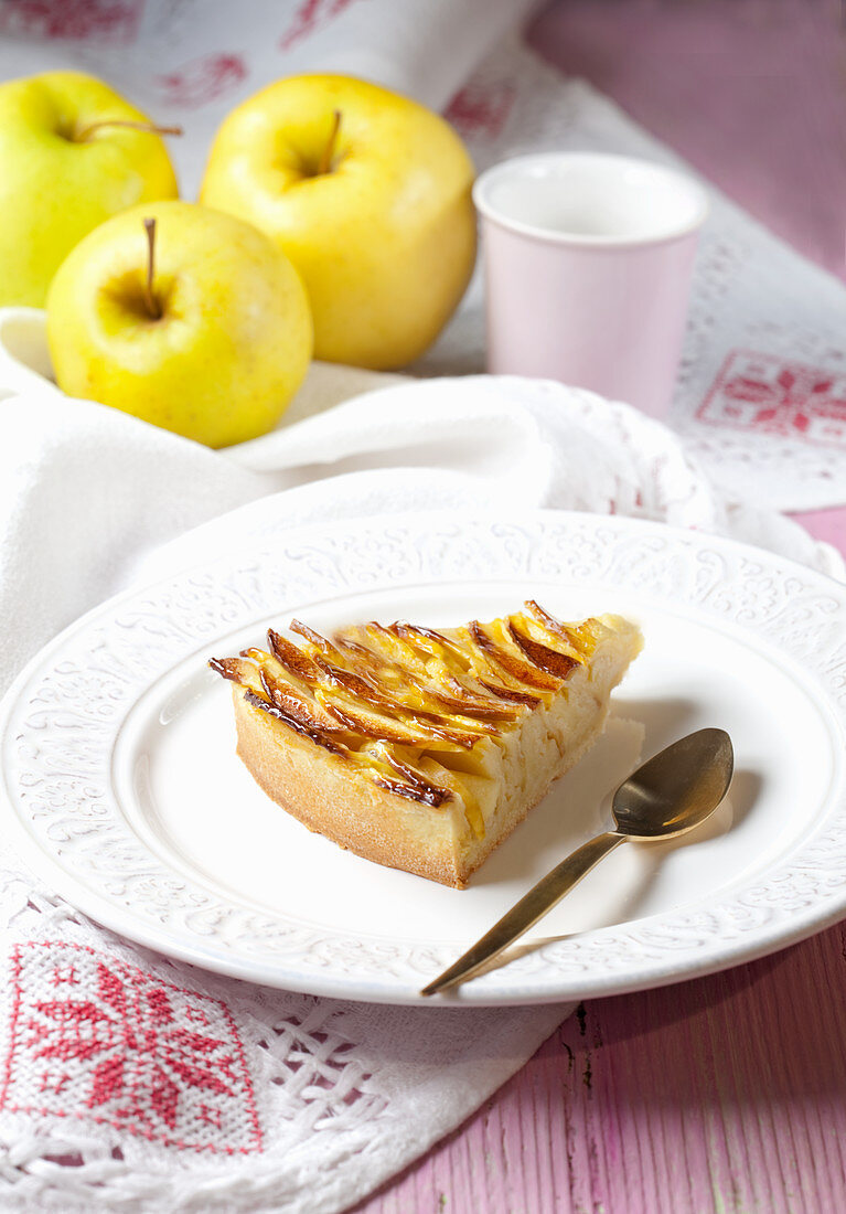 A slice of apple tart and fresh apples